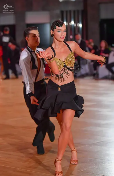 Dancesport competitor: Male dancer: white long-sleeved shirt, black waistcoat with tan trim, and black 