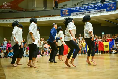 Dancesport competitor: All dancers are wearing white long-sleeved shirts and black trousers or leggings