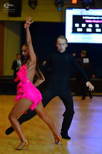 Dancesport competitor: Female dancer: bright pink latin dress with fringe