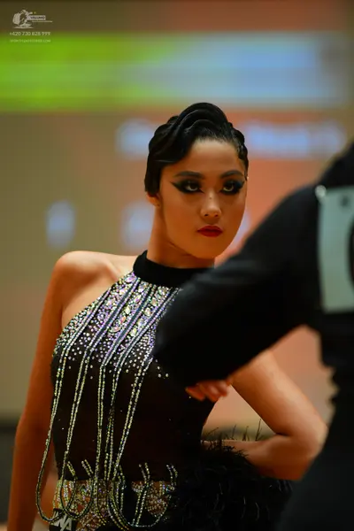 Dancesport competitor: Female dancer: black latin dress with a halter neck, heavily embellished with si