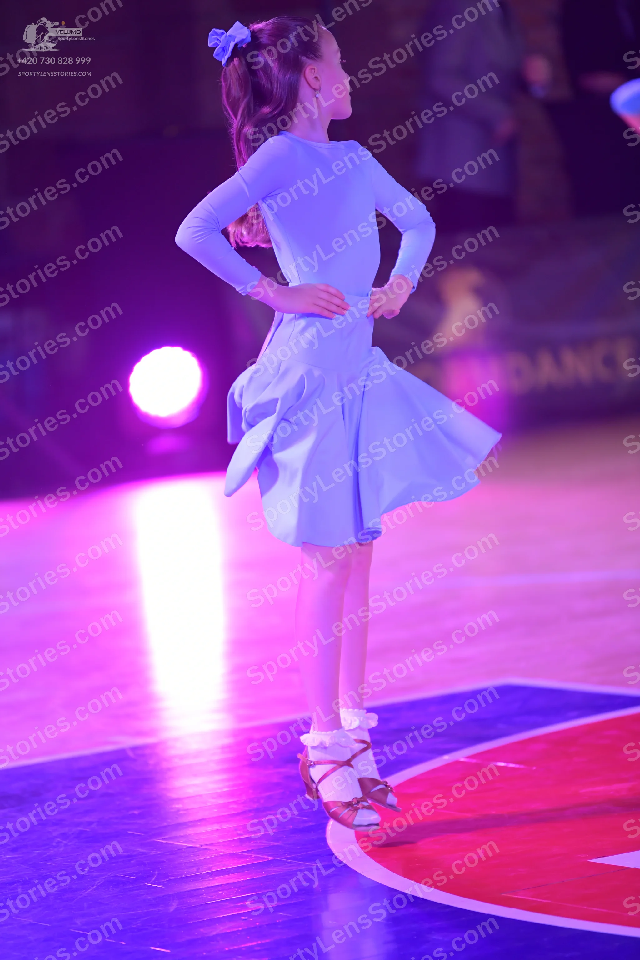 Dancesport competitor: Female dancer: light blue, long-sleeved Latin dress with a flared skirt and a li
