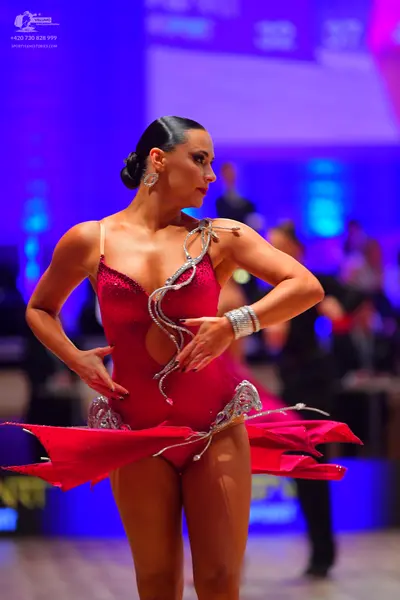 Dancesport competitor: Female dancer: red sequined Latin dance costume with silver rhinestone embellish