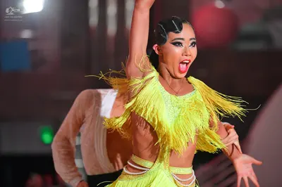Dancesport competitor: Female dancer: bright yellow latin dress with heavy fringe and cut-out details a