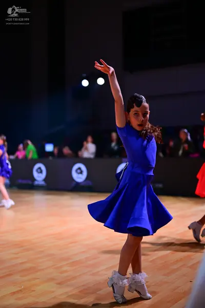 Dancesport competitor: Female dancer in center: royal blue short-sleeved dress with a flared skirt and 