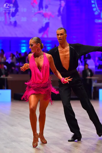 Dancesport competitor: Male dancer: black long-sleeved shirt with a deep V-neck and black trousers