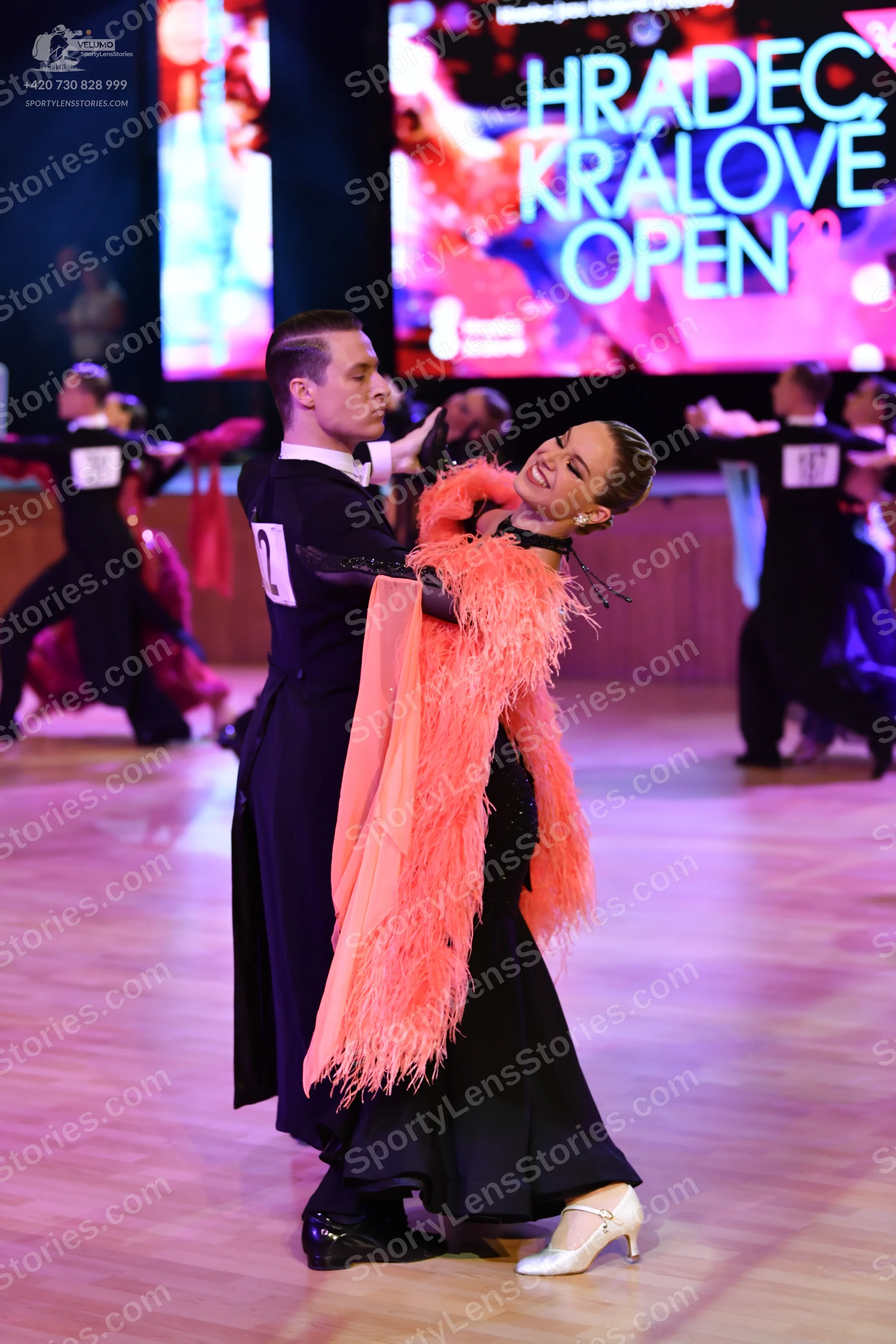 Dancesport competitor #27: Male dancer in foreground: black suit, black trousers, and black shoes