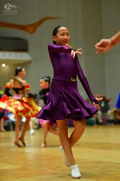 Dancesport competitor: Main dancer: purple, long-sleeved latin dress with a flared, ruffled skirt and s
