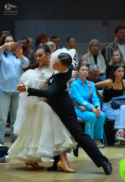 Dancesport competitor: Female dancer: white/ivory ballgown with a lace bodice and a voluminous, layered