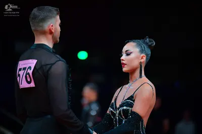Dancesport competitor: Male dancer: black long-sleeved sheer top with black lace/sequin side detail