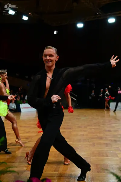 Dancesport competitor: Male dancer: black long-sleeved shirt and black trousers