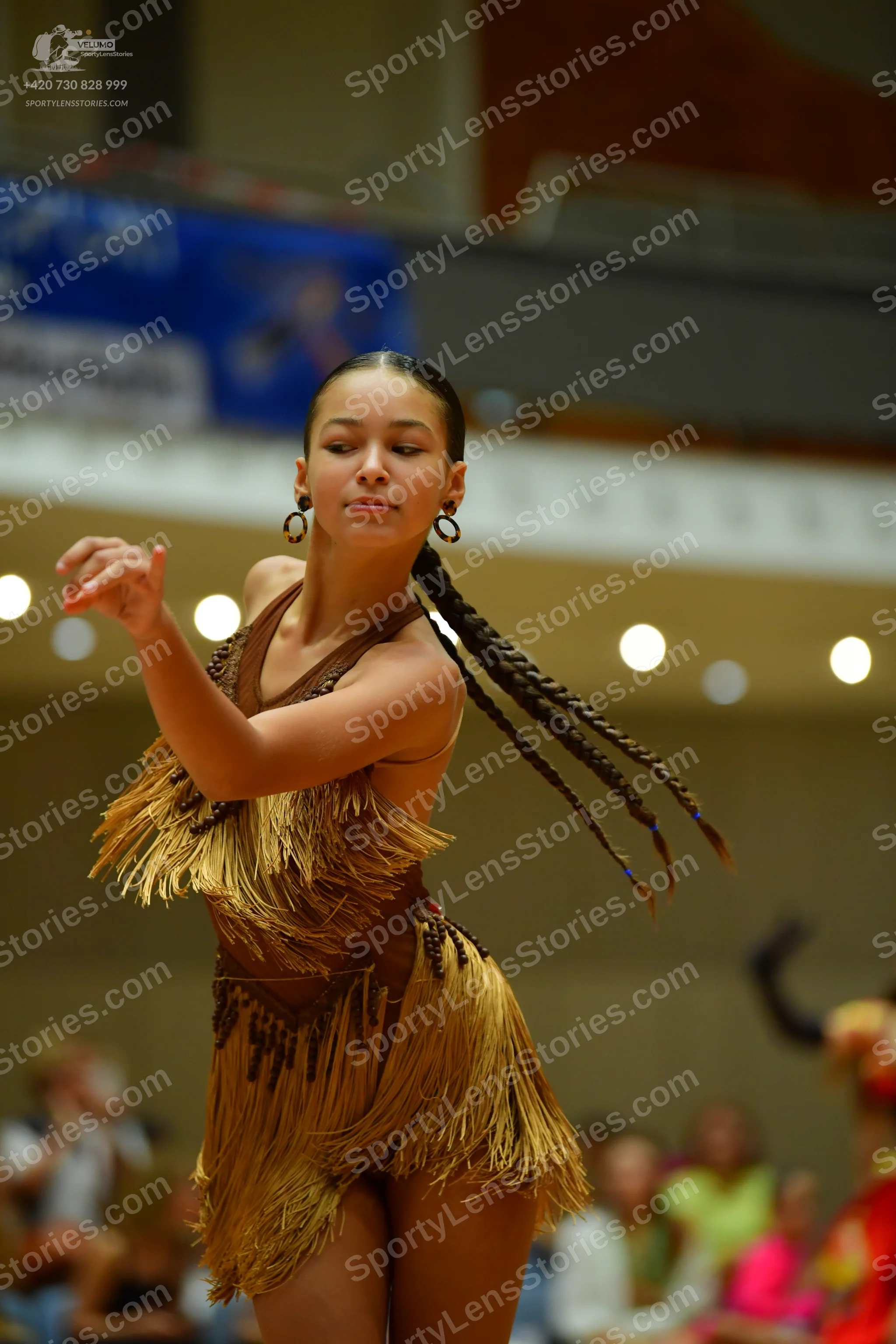 Dancesport competitor: Female dancer: brown latin dress with fringe and dark embellishments
