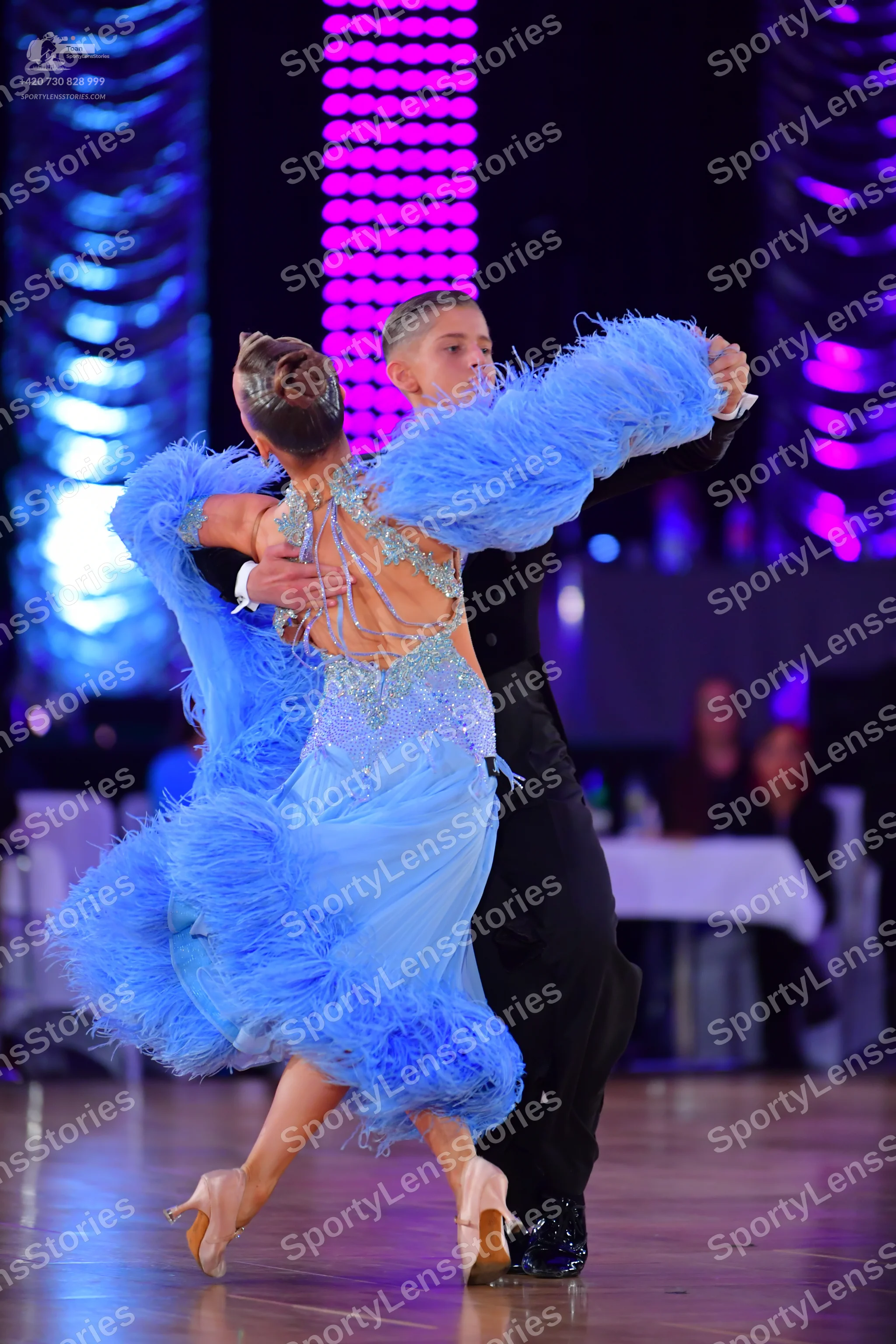 Dancesport competitor: Female dancer: light blue latin-style dress with feathers and sequins