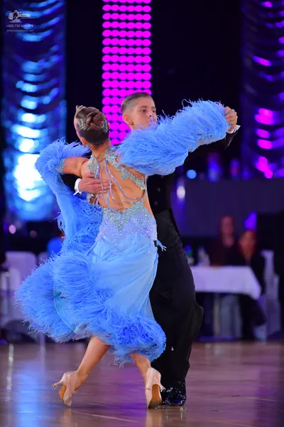 Dancesport competitor: Female dancer: light blue latin-style dress with feathers and sequins