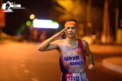 Marathon runner #42331: Runner 1: blue, white, and red tank top, orange headband, watch