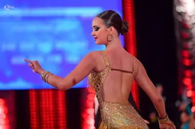 Dancesport competitor: Female dancer: champagne-colored sequined Latin dress with thin straps and an op