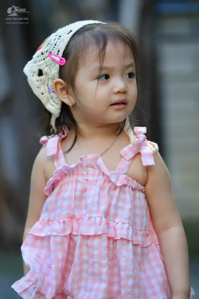 Dancesport competitor: Female dancer: pink and white gingham/checkered dress with ruffles and bow strap