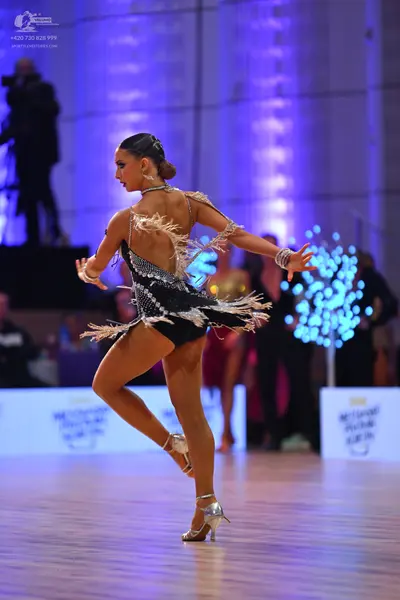 Dancesport competitor: Female dancer: black Latin dance costume with silver sequins and fringe, and sil