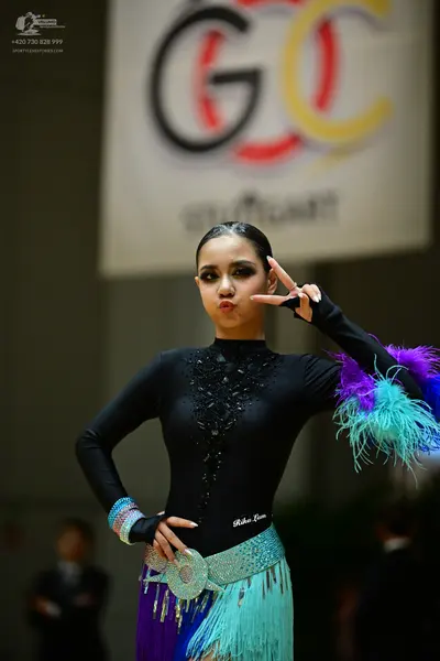Dancesport competitor: Female dancer: black long-sleeved Latin dress with sequin and lace detailing on 