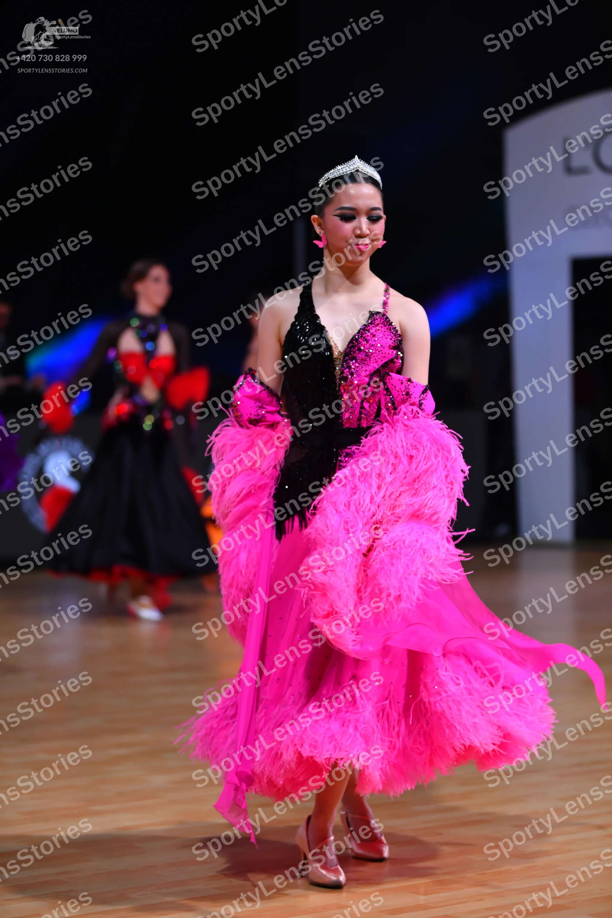 Dancesport competitor: Female dancer in foreground: black sequined latin-style bodice with a voluminous