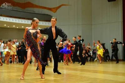 Dancesport competitor: Main female dancer: dark latin dress with colorful (purple, blue, pink) sequin f