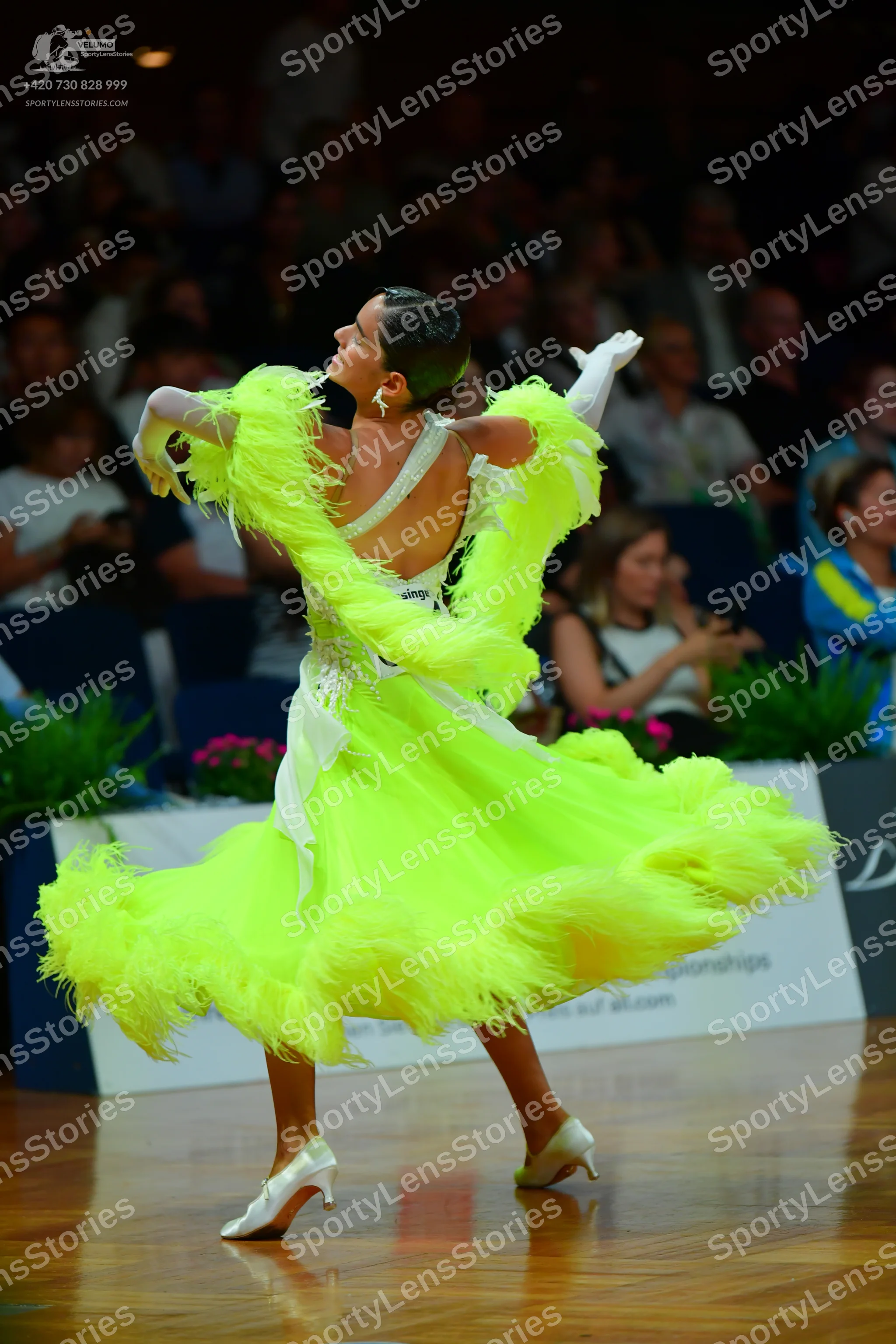 Dancesport competitor: Female dancer: neon lime green Latin dress with voluminous fringe or feather-lik