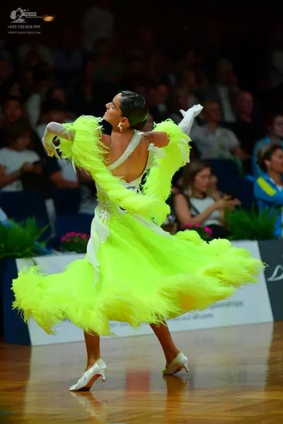 Dancesport competitor: Female dancer: neon lime green Latin dress with voluminous fringe or feather-lik