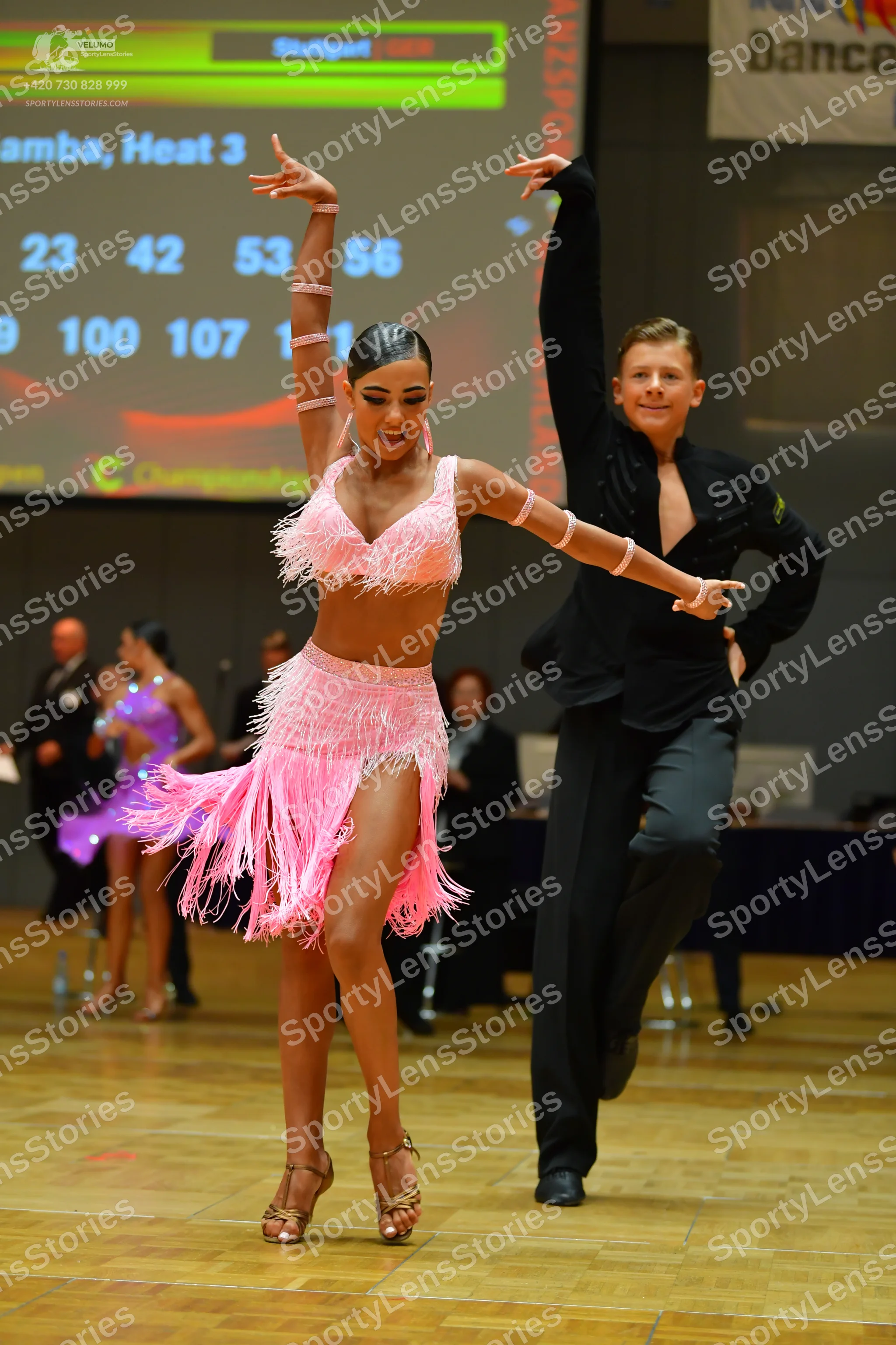 Dancesport competitor: Main female dancer: pink two-piece Latin costume with fringe