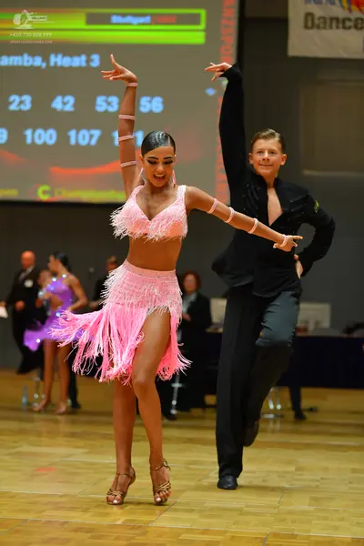 Dancesport competitor: Main female dancer: pink two-piece Latin costume with fringe