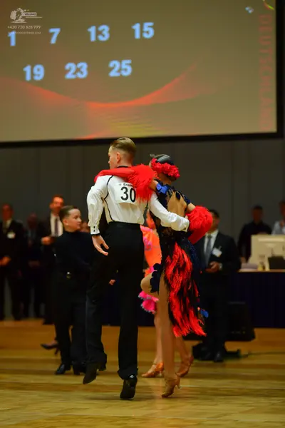 Dancesport competitor: Male dancer: white long-sleeved shirt with black trim and black trousers