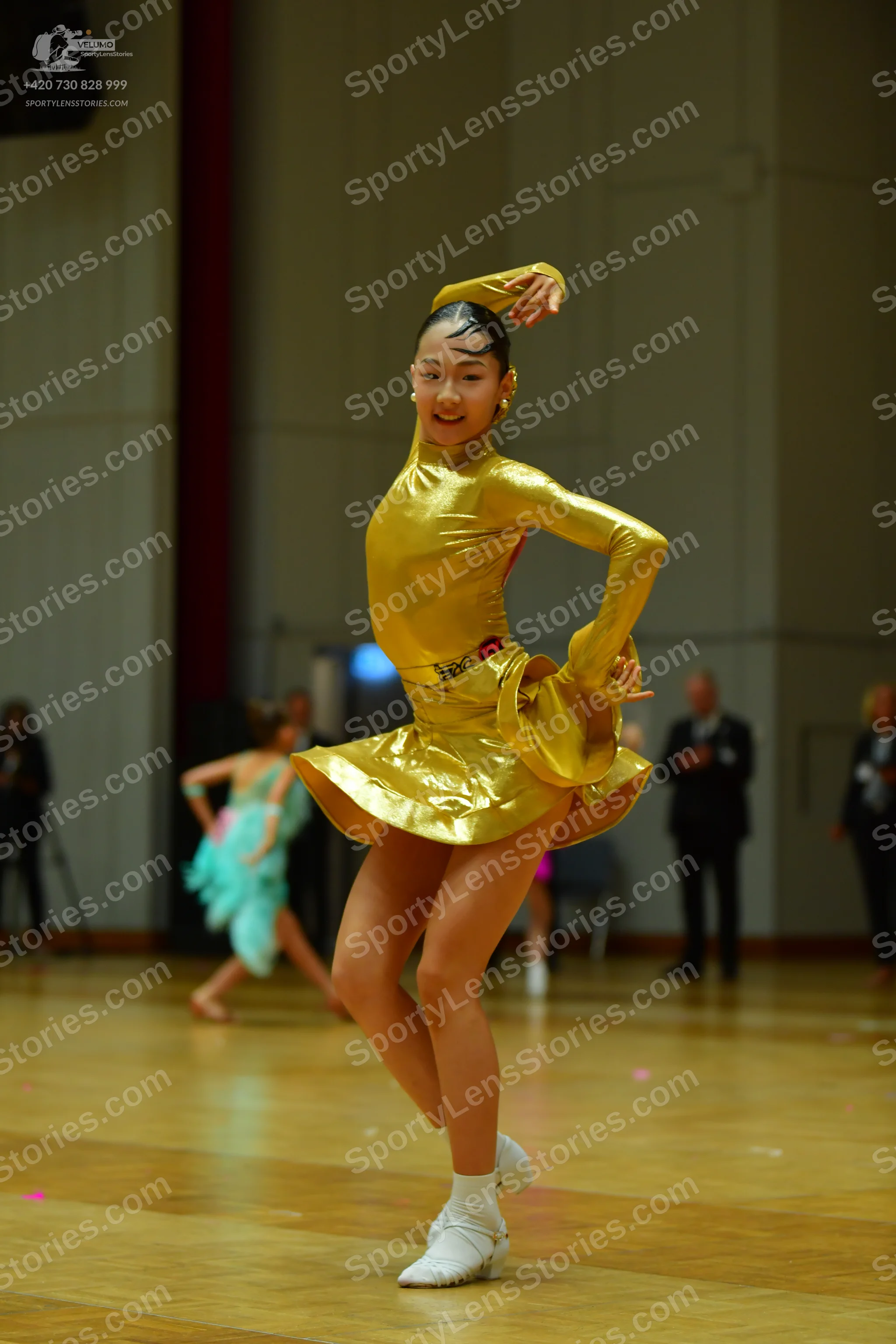 Dancesport competitor: Main dancer: gold metallic long-sleeved Latin dress with a flared skirt