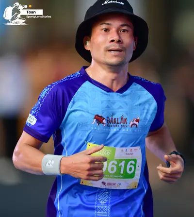 Marathon runner #0616: Runner 1: blue and purple jersey, black bucket hat, white wristband, black watch