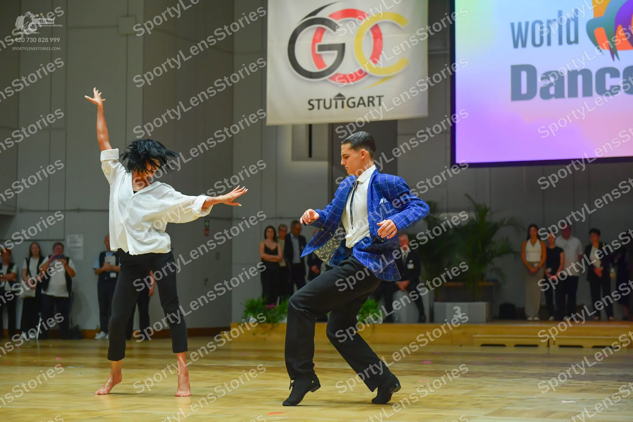 Dancesport competitor: Female dancer: white loose-fitting long-sleeved blouse and black leggings