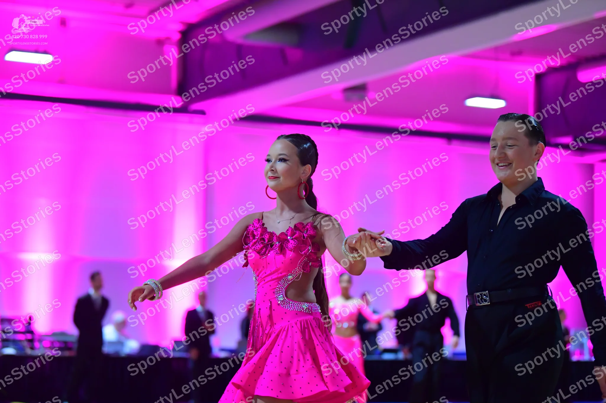 Dancesport competitor: Female dancer: bright pink latin dress with floral embellishments on the bodice