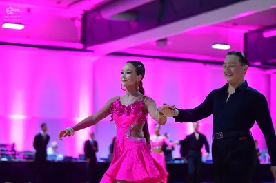 Dancesport competitor: Female dancer: bright pink latin dress with floral embellishments on the bodice