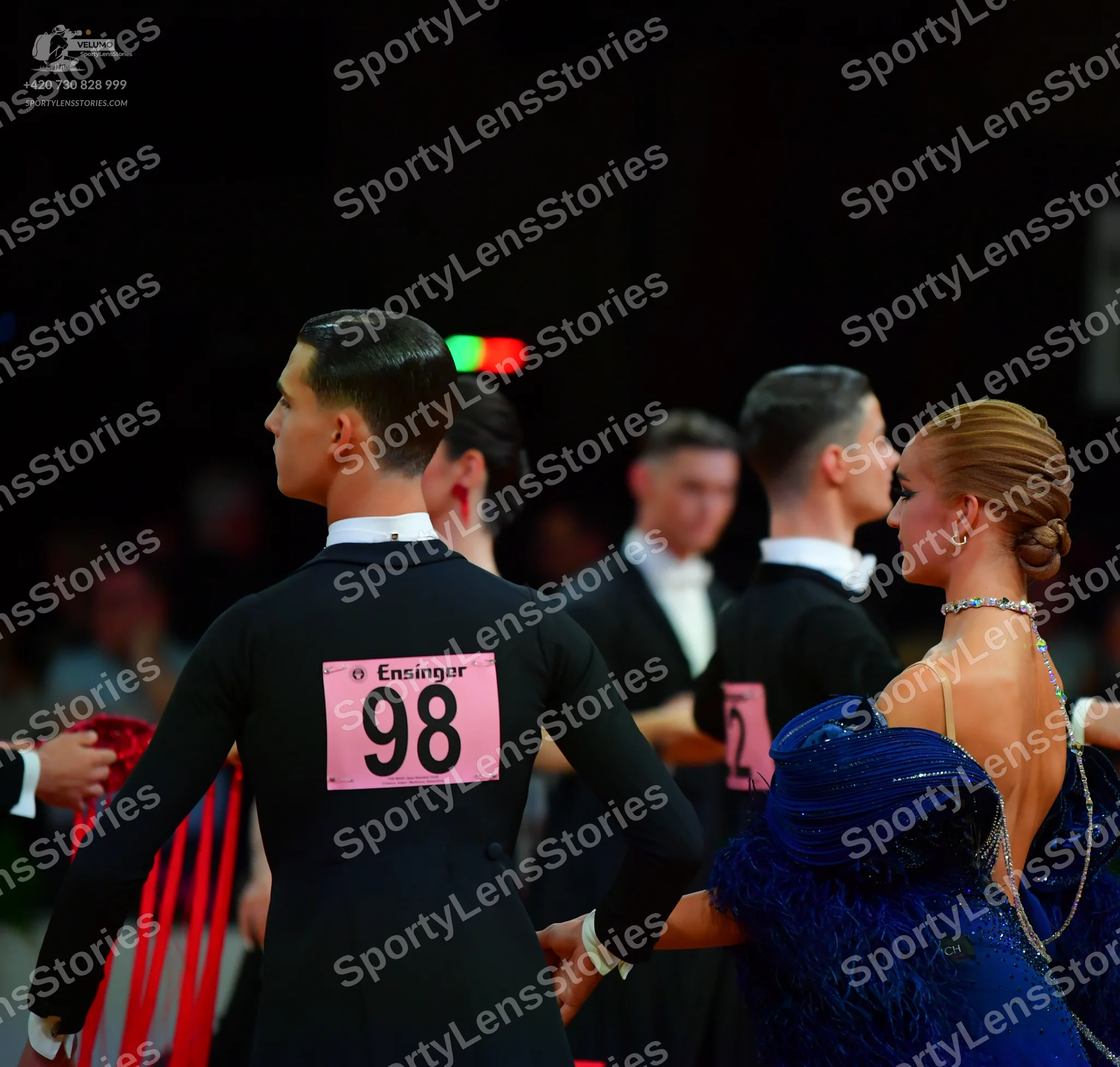 Dancesport competitor: Male dancer in foreground: black long-sleeved shirt
