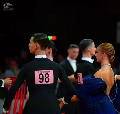 Dancesport competitor: Male dancer in foreground: black long-sleeved shirt