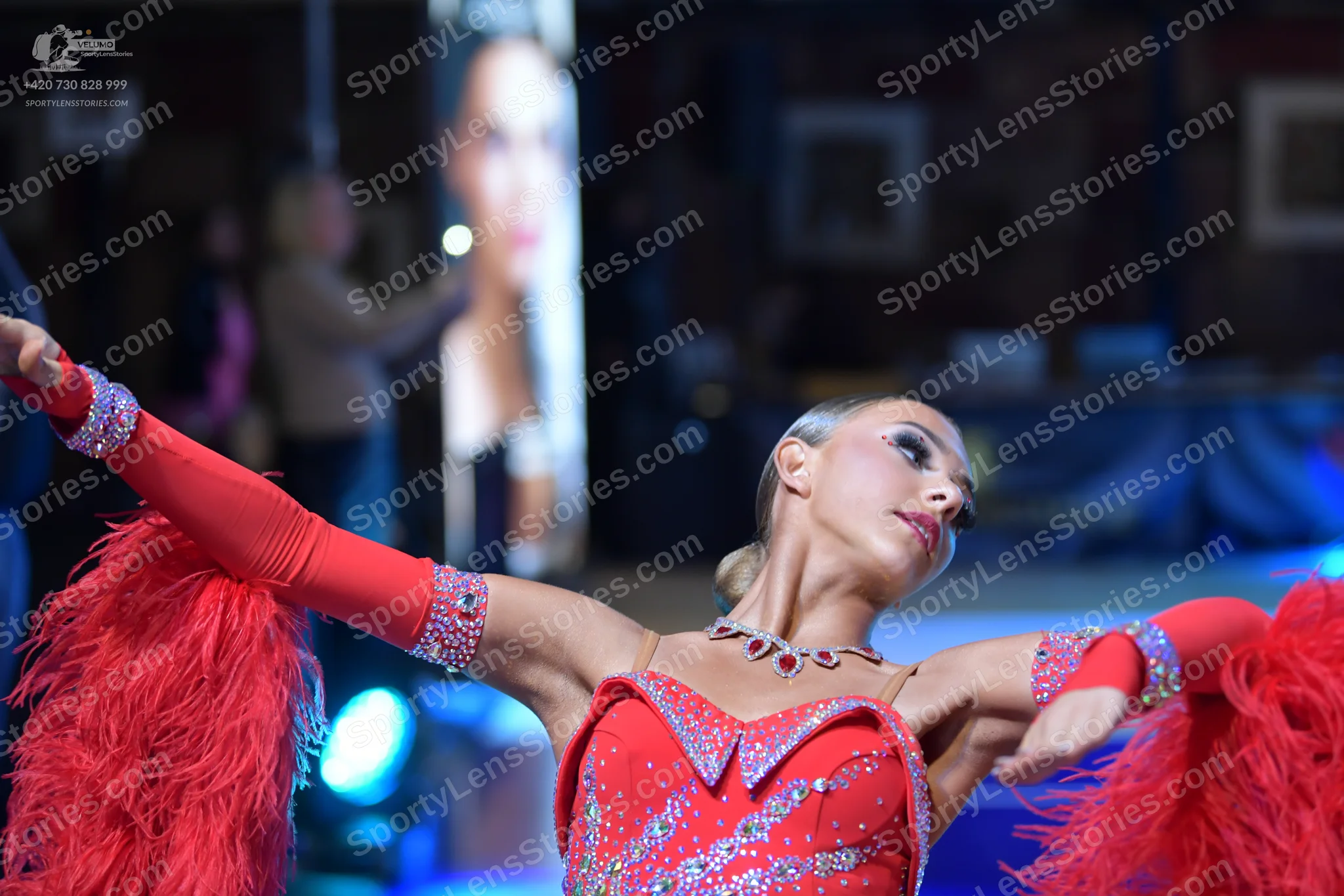 Dancesport competitor: Female dancer: red latin dance costume with heavy rhinestone embellishments, lar