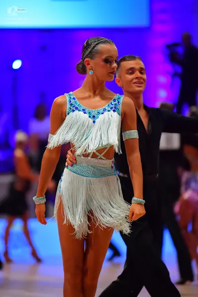 Dancesport competitor: Female dancer: light blue Latin dress with blue sequins around the neckline and 