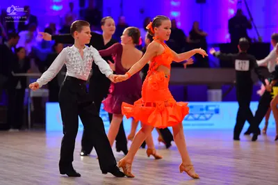 Dancesport competitor: Male dancer: white long-sleeved shirt with a black patterned design on the chest