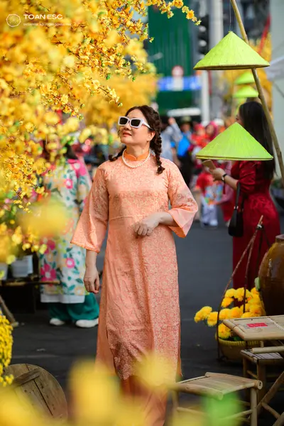 Dancesport competitor: Female dancer in foreground: light peach/apricot long tunic (ao dai style) with 