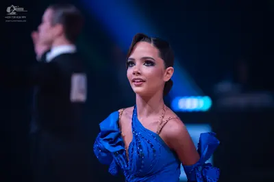 Dancesport competitor: Female dancer: blue Latin dress with ruffles on the sleeve and small sparkling e