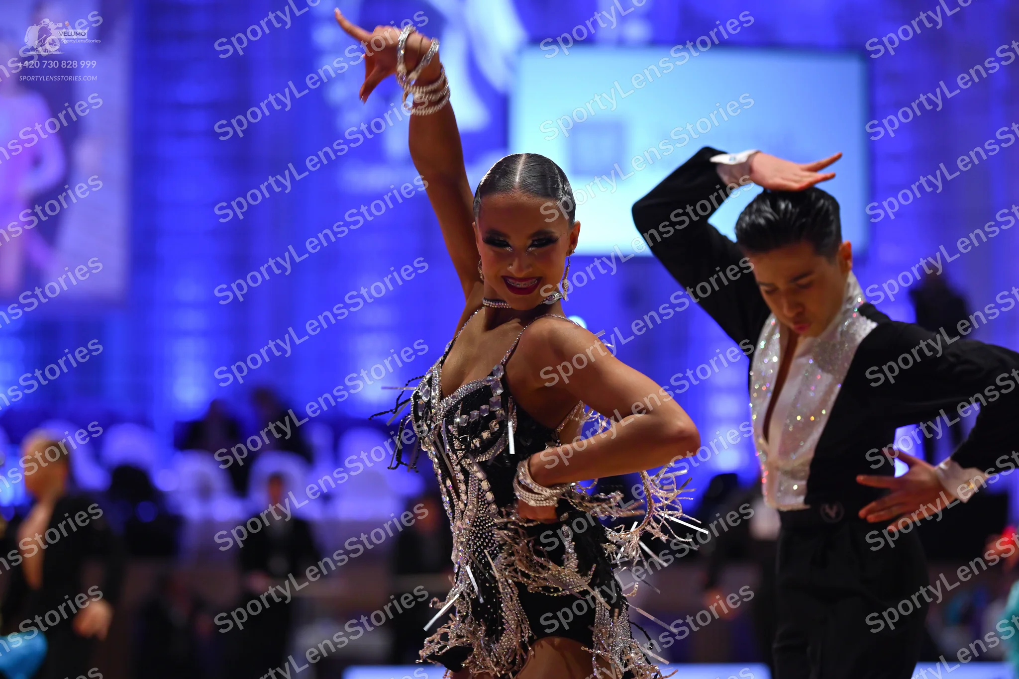 Dancesport competitor: Male dancer: black Latin dance costume with a white, possibly sequin-embellished