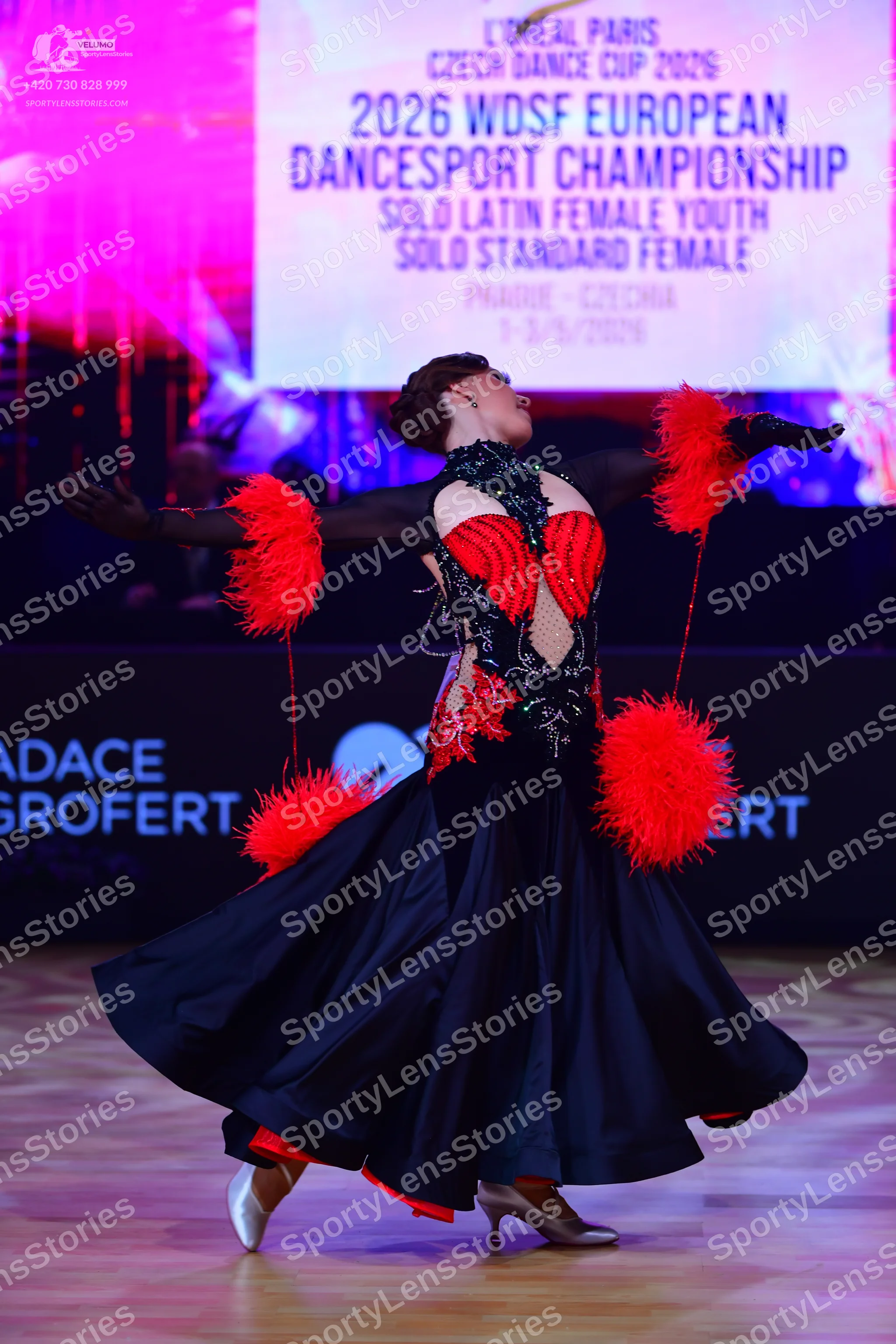 Dancesport competitor: Female dancer: black ballroom dress with a red and black sequined and lace bodic