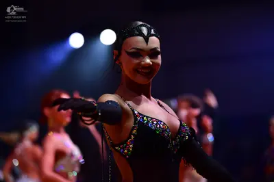 Dancesport competitor: Main dancer: black latin-style dress with multi-colored sequins (pink, blue, yel