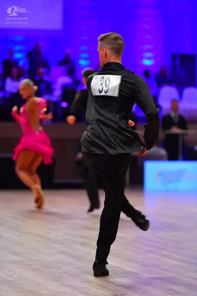 Dancesport competitor: Male dancer: black long-sleeved satin-like shirt and black trousers