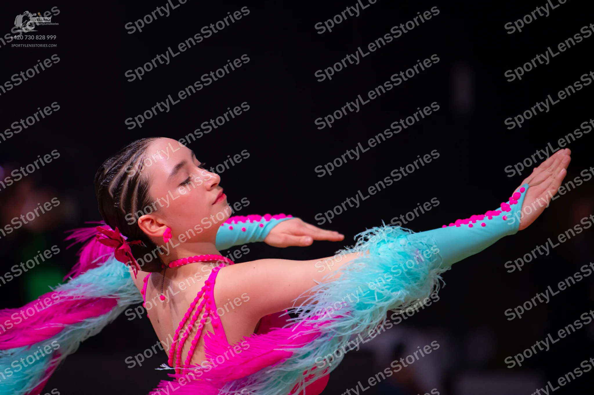 Dancesport competitor: Female dancer: bright pink and light turquoise Latin dance dress with feathery t