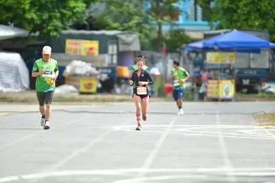 Marathon runner #441: Runner 1: green jersey, black shorts, white cap, white shoes