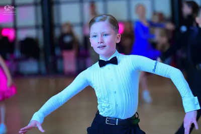 Dancesport competitor: Male dancer: light blue textured long-sleeved shirt, black bow tie, and black tr
