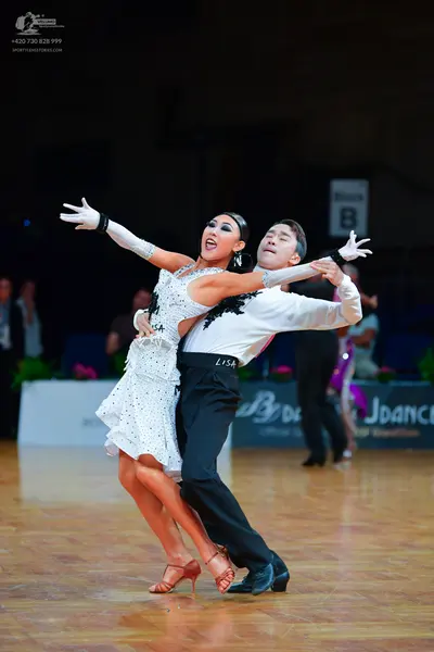 Dancesport competitor: Female dancer: white latin dress with black lace/sequin detailing, white long gl