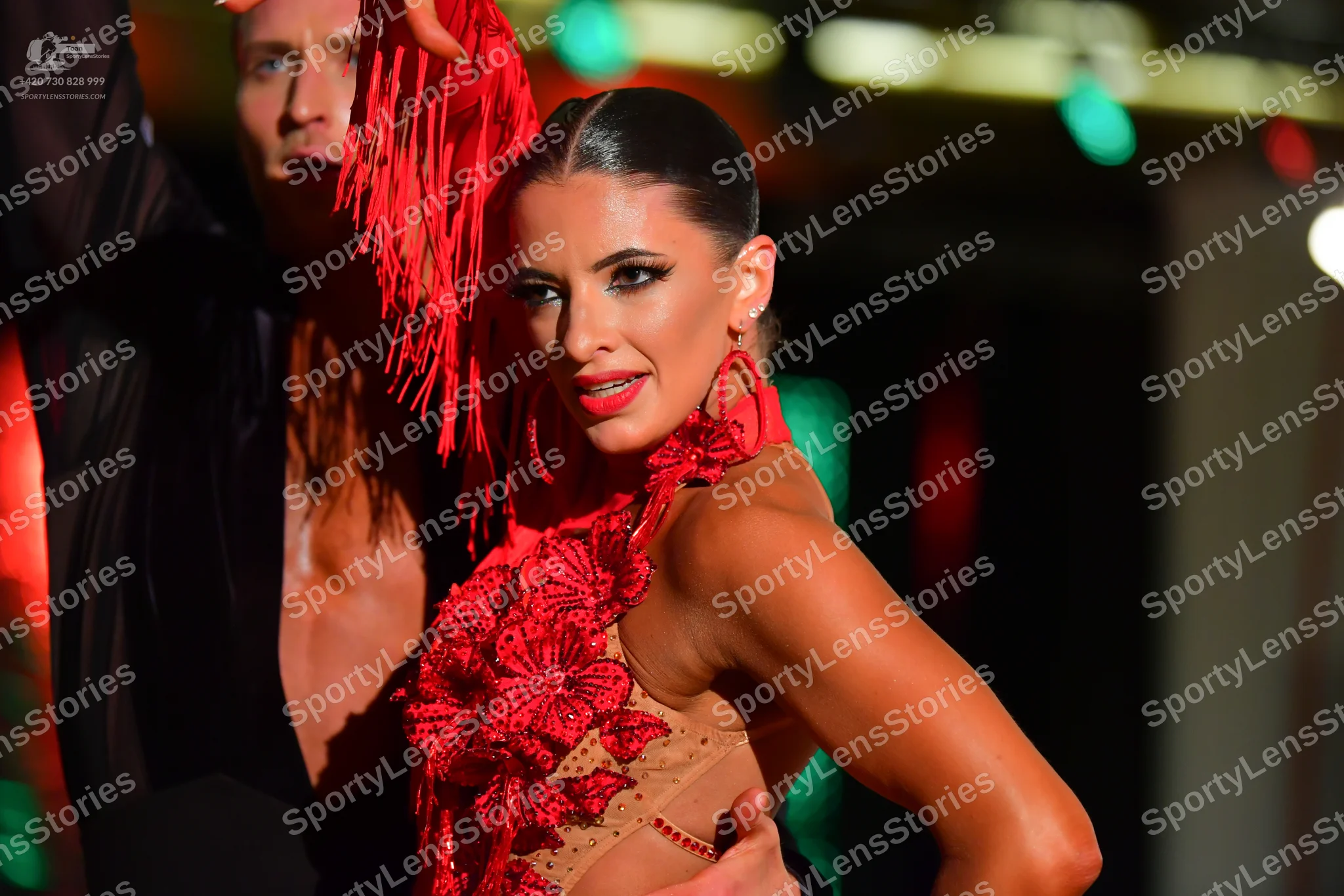Dancesport competitor: Female dancer: red Latin dance dress with red floral lace/appliqué over a nude-c